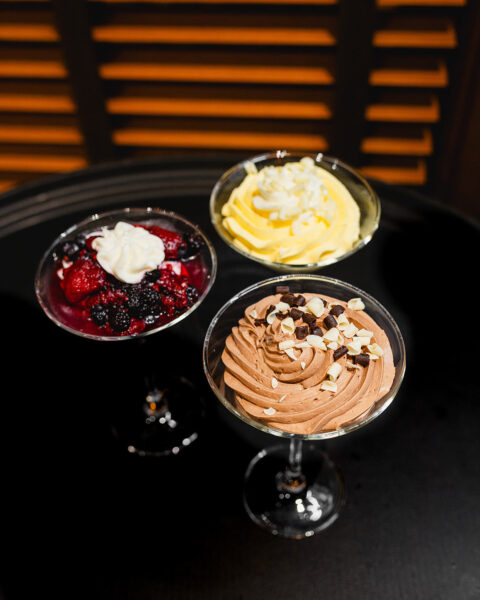 three desert glasses on a black table