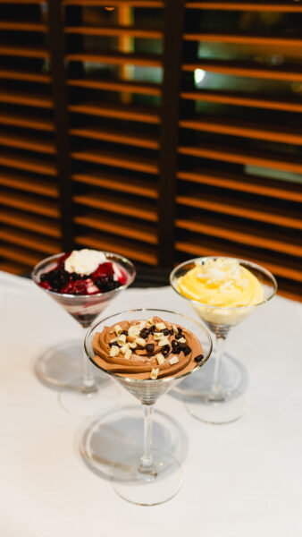three desert glasses on a black table