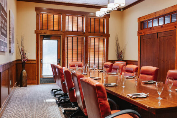 long table with office chairs and fancy glasses