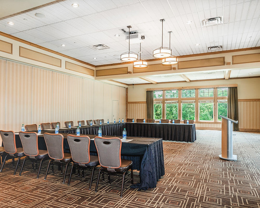 Podium, tables and chairs for meeting presentation set up in the North Ballroom at Bunker Hills Event Center