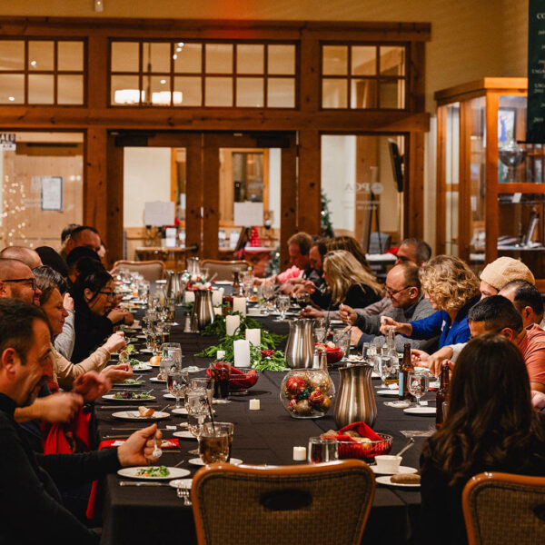 group of people dining at a long festive table