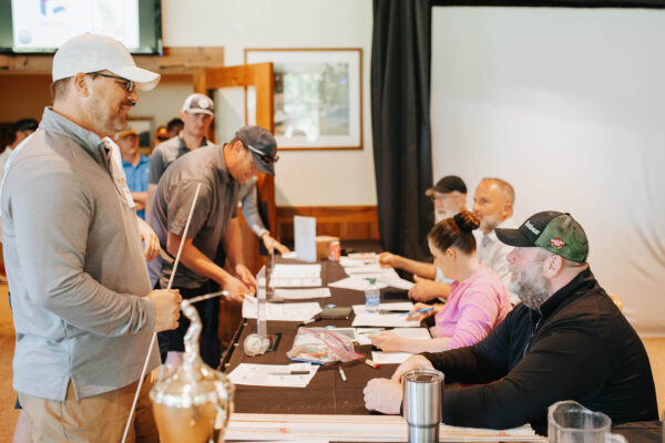 smiling people gathered around sign-up table