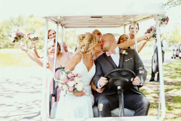 Bride and groom driving a golf cart