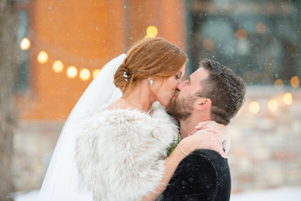 Bride and groom posing for wedding photos in a snowy landscape