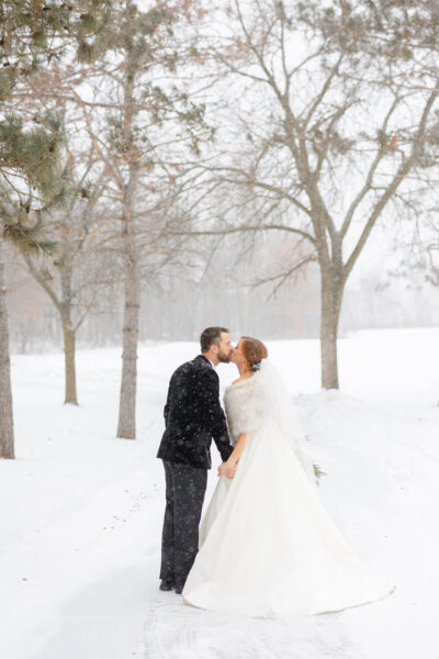 Bride and groom posing for wedding photos in a snowy landscape