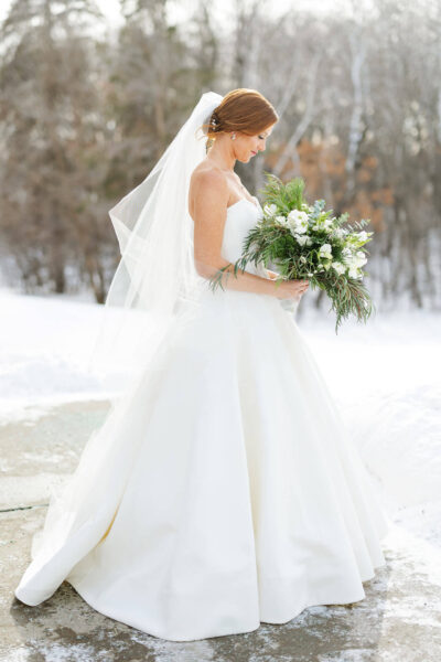 Bride posing for photo in a snowy landscape
