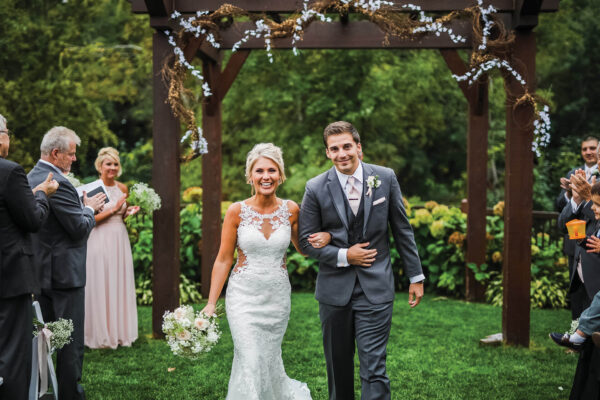 newly wed bride and groom posing walking down the isle