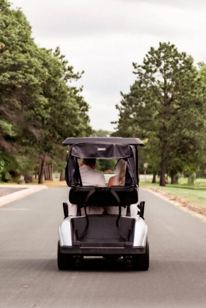 Bride and groom driving a golf cart
