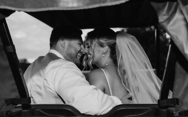 couple posing for wedding photos in a golf cart