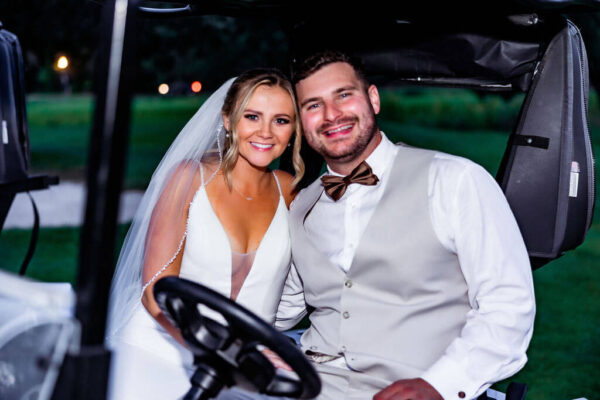 couple posing for wedding photos in a golf cart