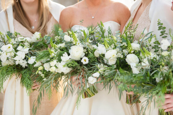 bride and bridesmaids holding bouquets of white flowers