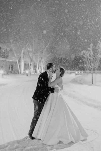 couple posing for wedding photos in snowy landscape
