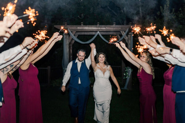 bride and groom walking by guests with sparklers