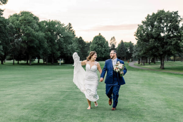 couple posing for wedding photos on golf course