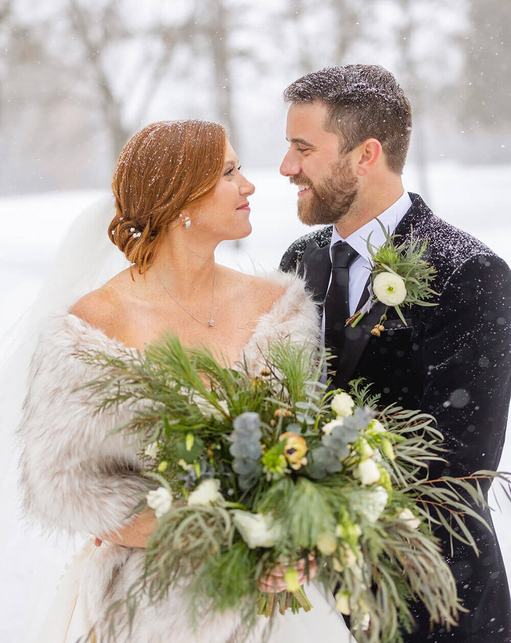 bride and groom posing for photo in the snow